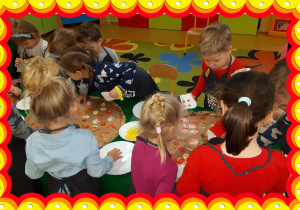 Dzieci tworzą pizze z materiałów plastycznych.